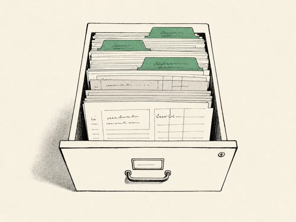 An ink filing drawer of patient cards, several older cards tabbed in green